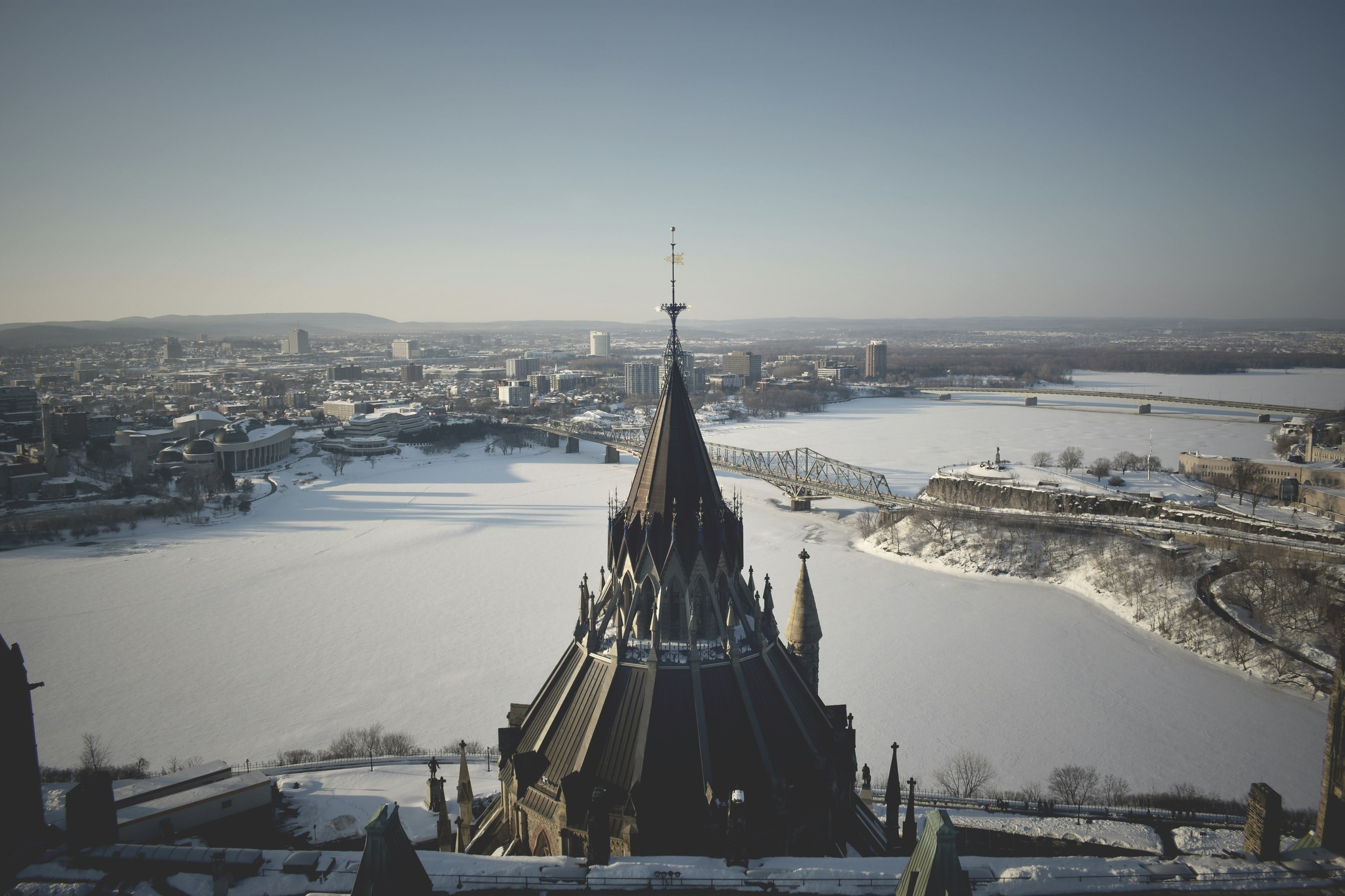 Blick auf ein schneebedecktes Stadtgebiet mit einem Kirchturm im Vordergrund.