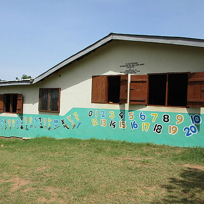 Schulgebäude in Ghana mit bemalter Fassade, auf der bunte Zahlen abgebildet sind.