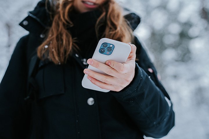 Person mit Smartphone im Winter