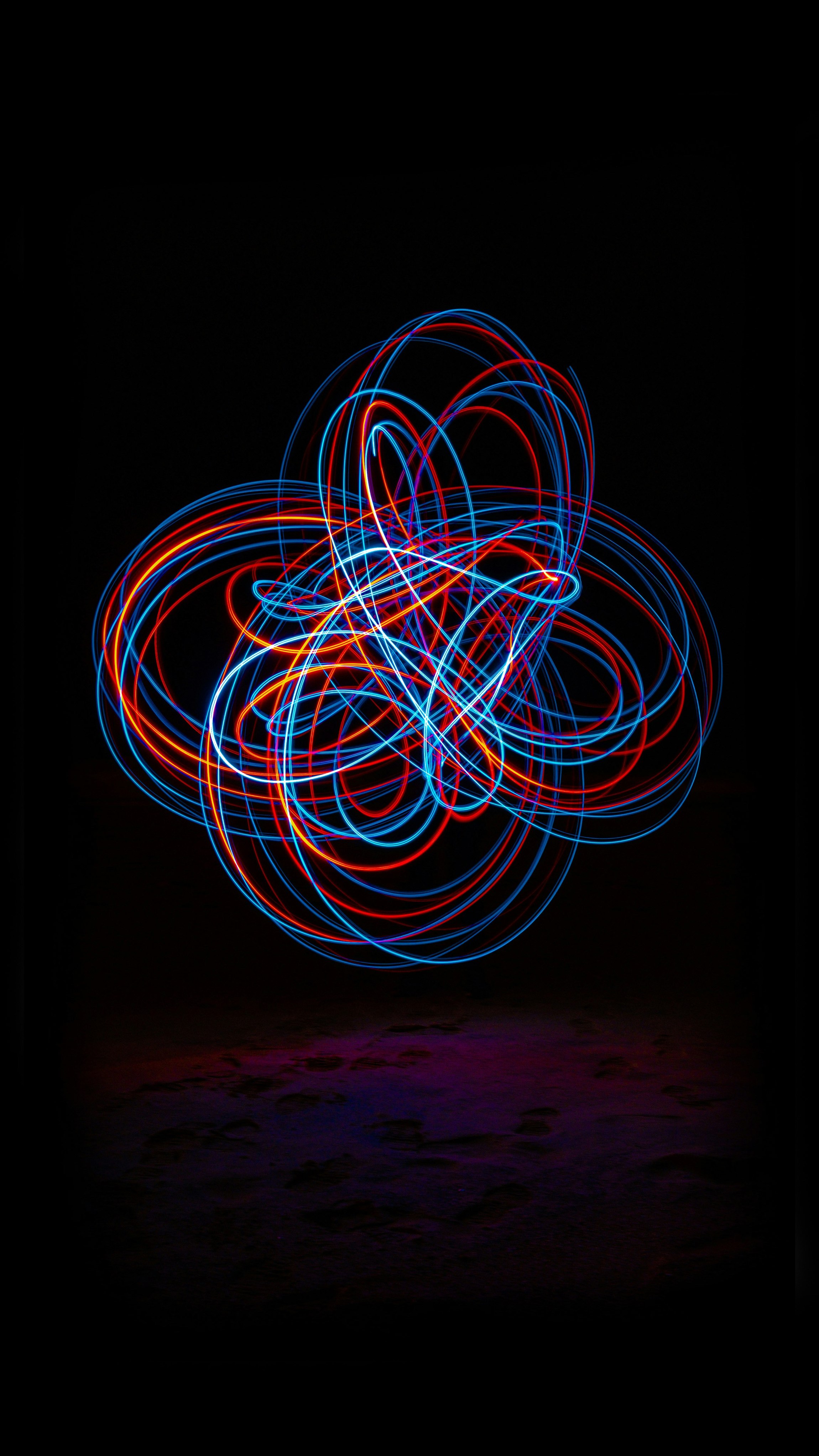  Leuchtende bunte Lichtspuren bilden ein abstraktes Muster vor schwarzem Hintergrund.