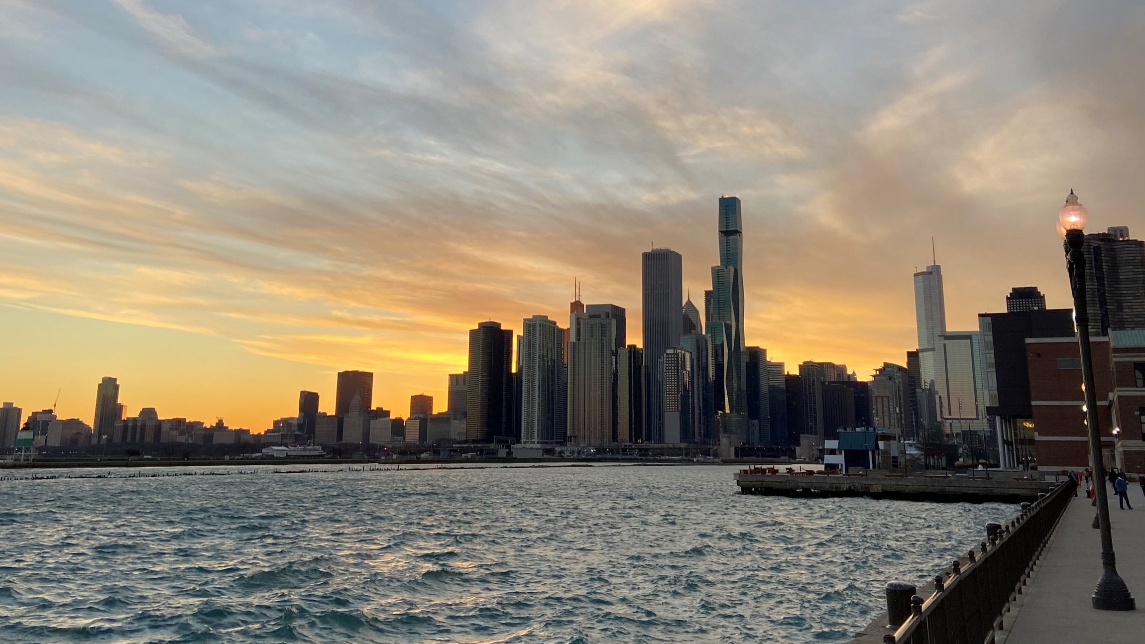 Stadtansicht mit Hochhäusern am Wasser bei Sonnenuntergang.