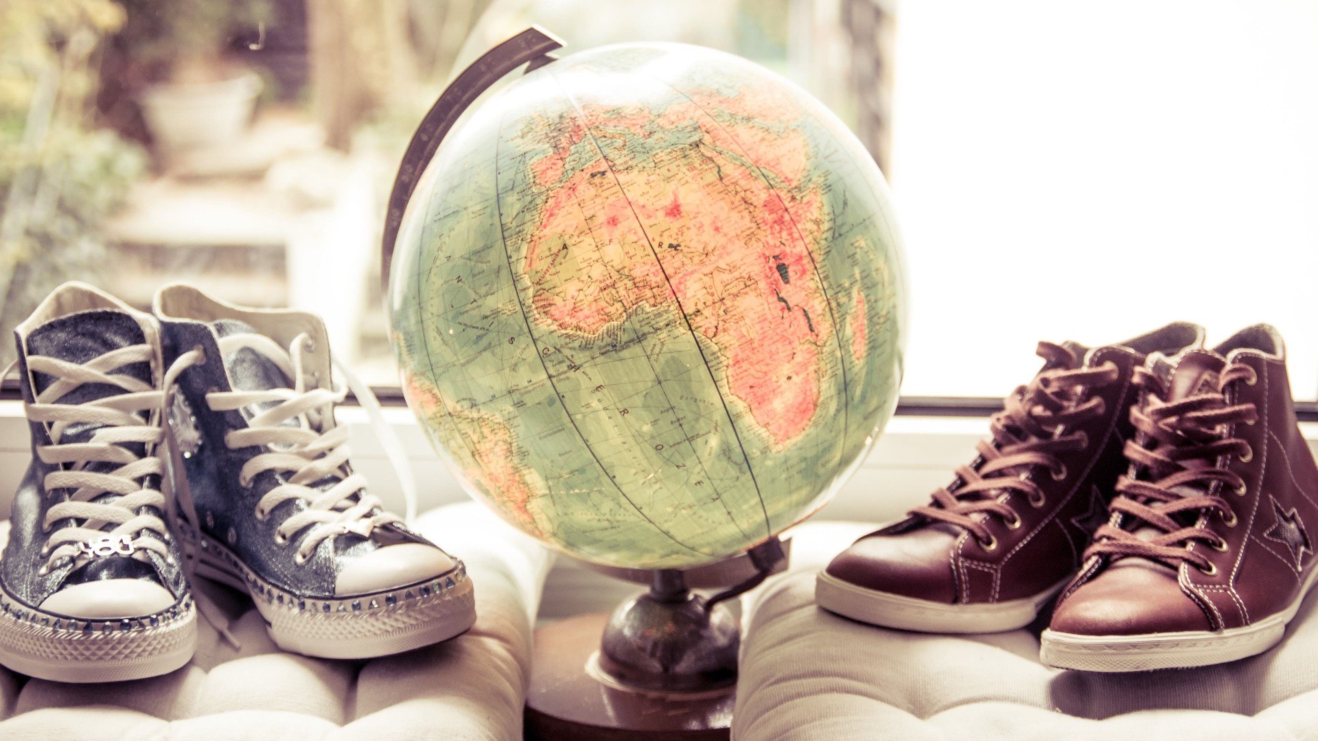 zwei Paar Schuhe stehen neben einem Globus