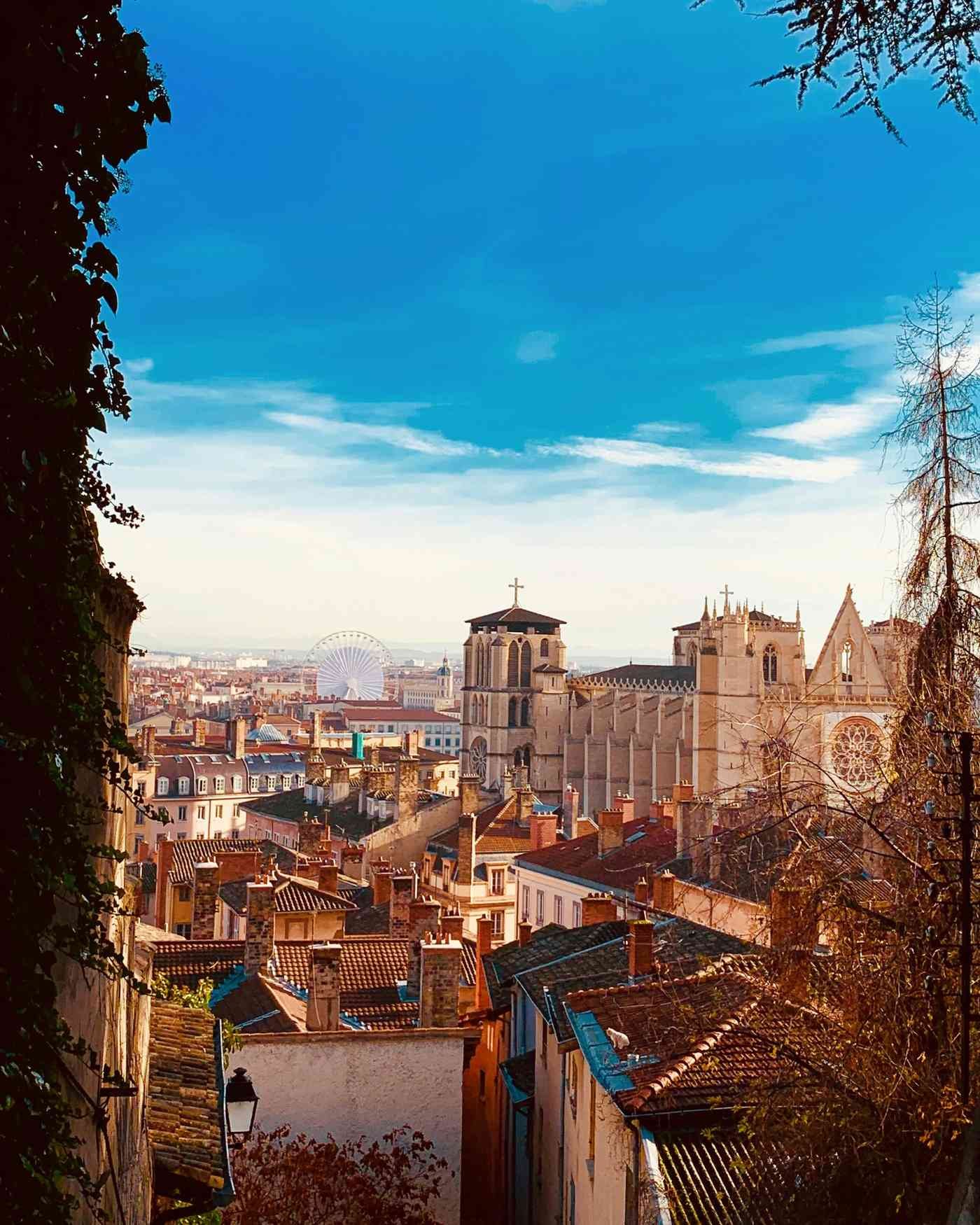 Blick über die Altstadt mit der Kathedrale und den roten Dächern unter blauem Himmel.